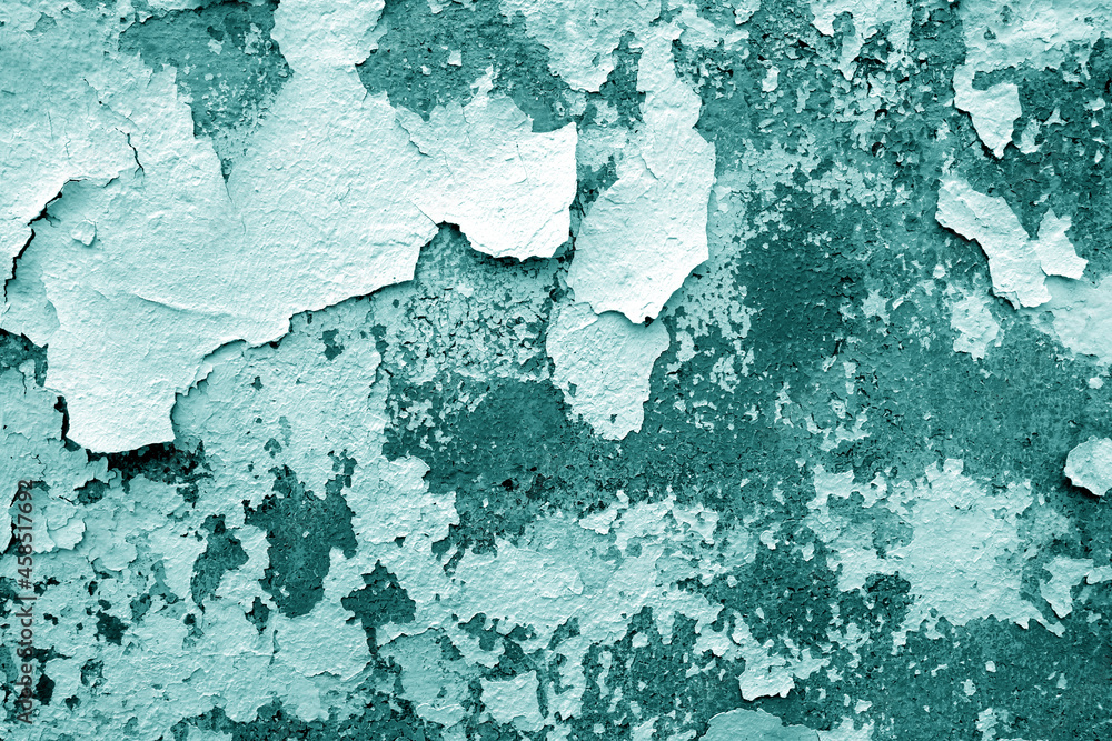 Сement wall with peeling paint and plaster in cyan tone.