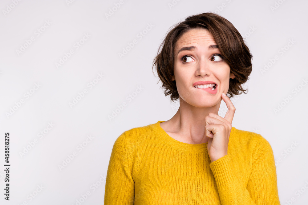 Photo of stressed brunette millennial lady look empty space wear yellow shirt isolated on grey color background Photo of stressed brunette millennial lady look empty space wear yellow shirt isolated on grey color background