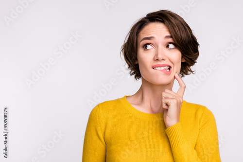 Photo of stressed brunette millennial lady look empty space wear yellow shirt isolated on grey color background