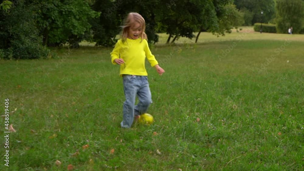 Camera movement on little girl runs and laughs with soccer ball on green lawn in summer park. Happy child plays in football in nature. Sport Camera movement on little girl runs and laughs with soccer ball on green lawn in summer park. Happy child plays in football in nature. Sport