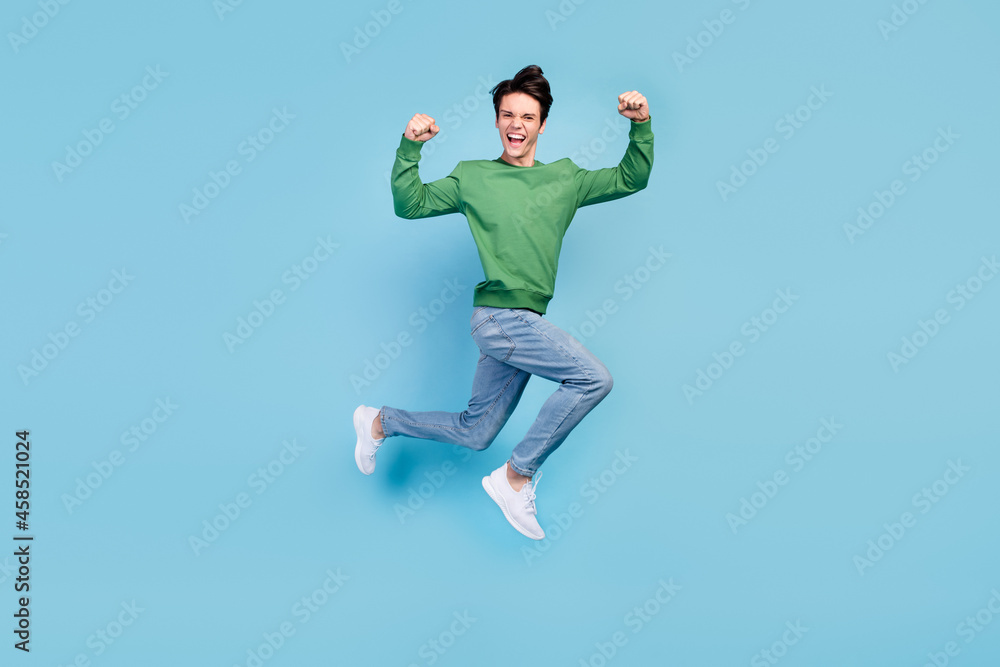 Full length body size photo guy jumping up showing strong hands isolated pastel blue color background