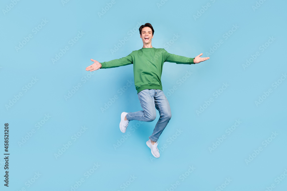 Full length body size photo guy jumping high inviting friends embracing smiling isolated pastel blue color background