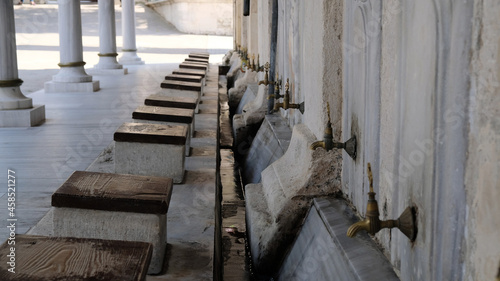 Ablution or wudhu station at mosque in Istanbul  Turkey. Faucets for ritual ablution and stones to sit on near a mosque in Islamic culture. Turkish Ottoman style water tap.