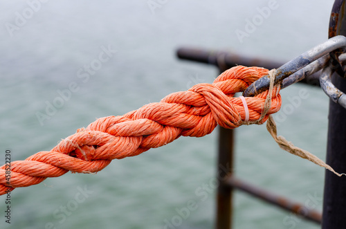Marine rope. Synthetic rope fence. Metal carabiner. Cable. Knot.
