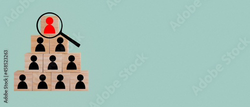 The search for new executives to lead organizations and teams is shown with wooden cubes, magnifying glass, and human resources icons. The concept of organizational hierarchy and multilevel marketing.