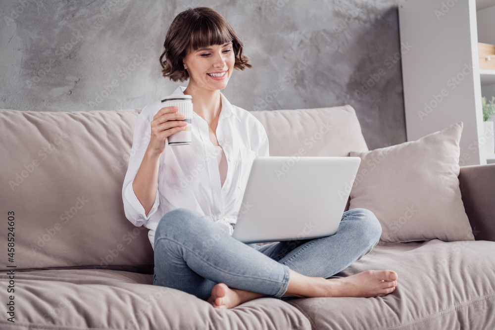 Photo portrait woman wearing white shirt using computer watching movie relaxing drinking coffee at home on couch Photo portrait woman wearing white shirt using computer watching movie relaxing drinking coffee at home on couch