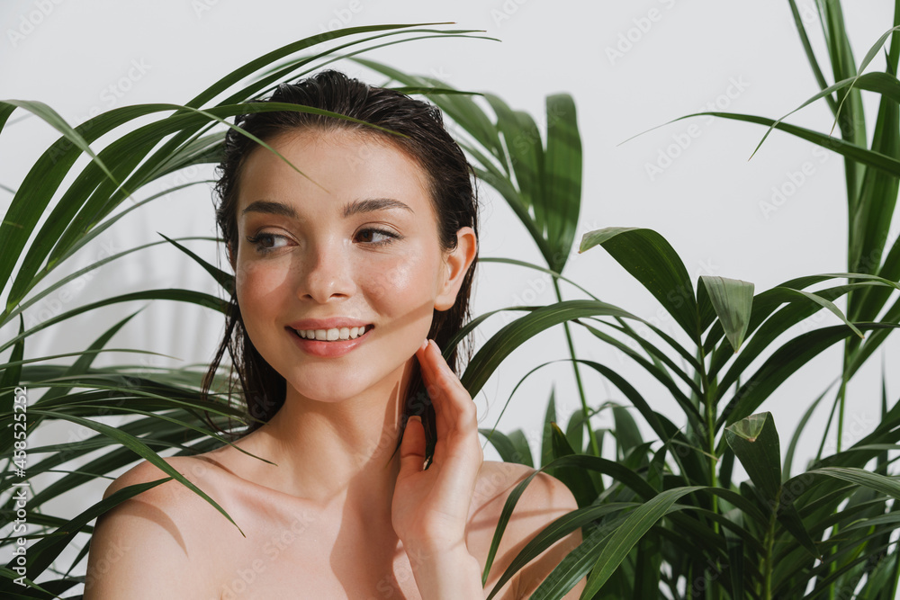Young half-naked woman posing with plants on camera Young half-naked woman posing with plants on camera