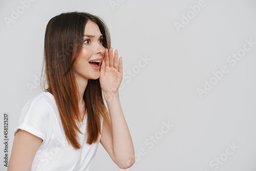Young ginger woman in t-shirt gesturing and screaming aside