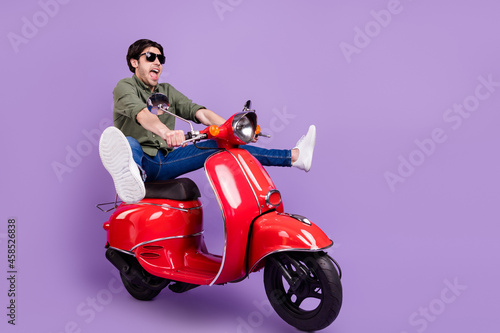 Full body photo of amazed excited happy cheerful man wear sunglass rider empty space isolated on violet color background