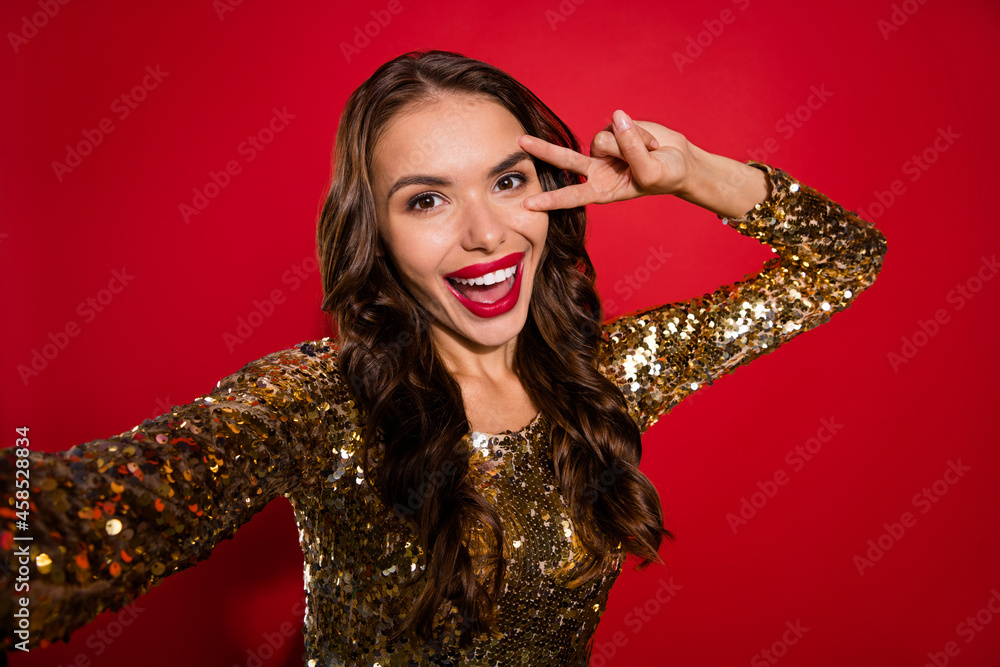 Photo of cheerful happy attractive nice woman make selfie smile v-sing good mood isolated on red color background Photo of cheerful happy attractive nice woman make selfie smile v-sing good mood isolated on red color background