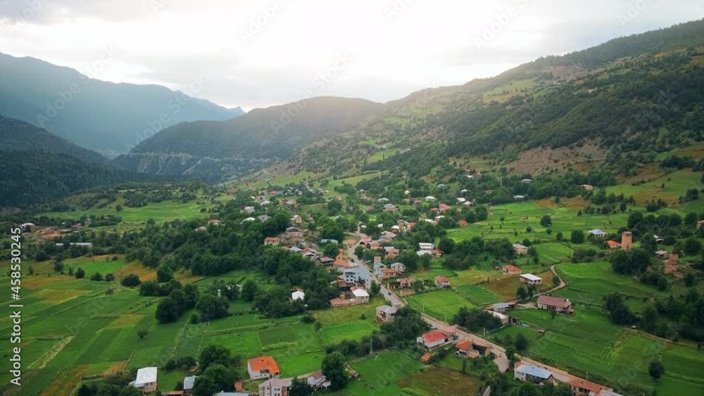 Aerial drone view of a village in Georgia. Valley, buildings, mountains and hills slopes covered with greenery Aerial drone view of a village in Georgia. Valley, buildings, mountains and hills slopes covered with greenery