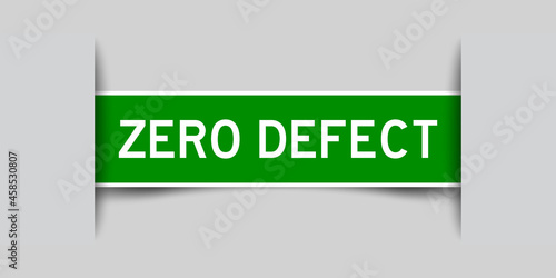 Inserted green color label sticker with word zero defect on gray background