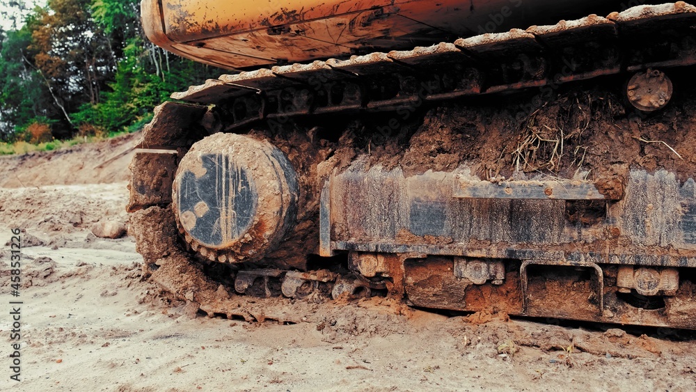 Industrial Heavy Duty Excavator Bulldozer Continuous Tracks Covered with Mud on Construction Site