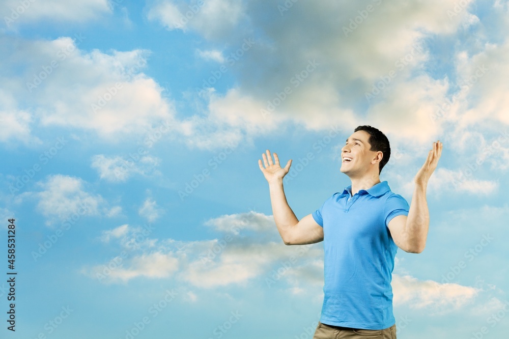 Young man rising on blue sky white clouds abstract background. Freedom feel good Young man rising on blue sky white clouds abstract background. Freedom feel good
