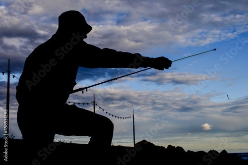 Young fisherman silhouette with a fishing rod.