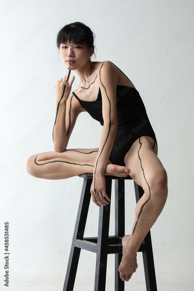 Portrait of young adorable Japanese ballerina sitting on high chair and  thinking isolated on light gray studio background. Beauty, line art, inner  world concept. Stock-Foto | Adobe Stock