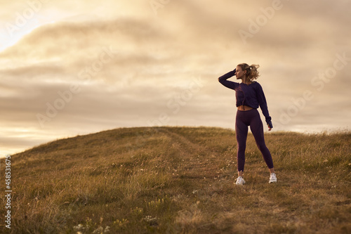 Fit woman resting after jogging in nature