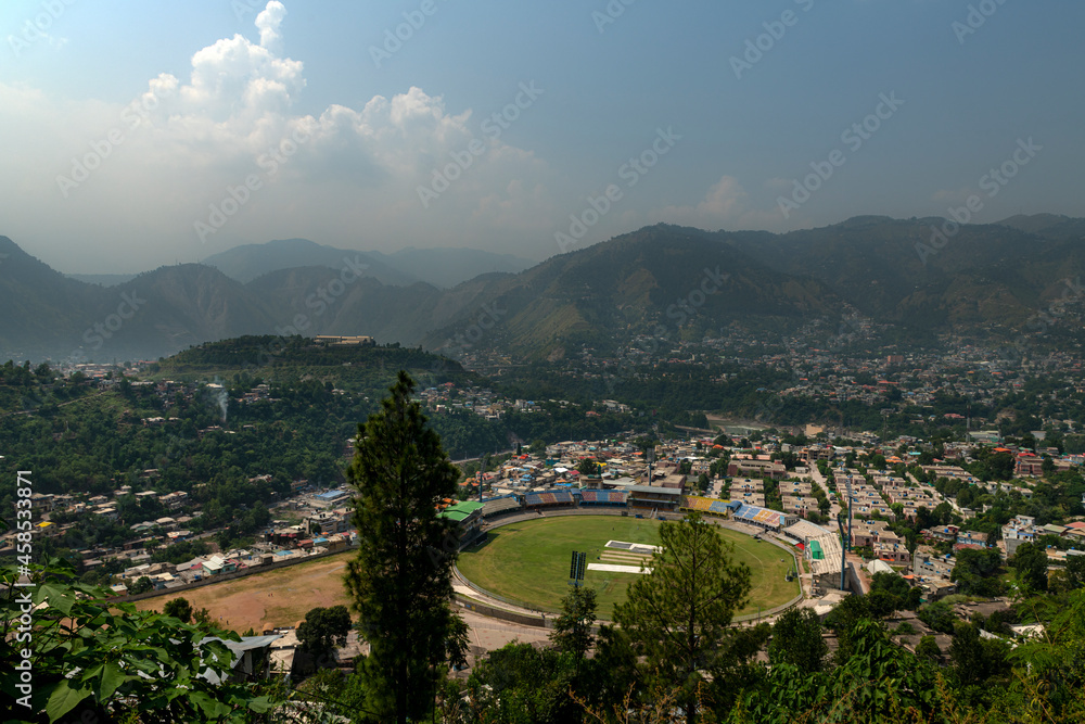 view of the city , mountain city with green meadows and blue sky 