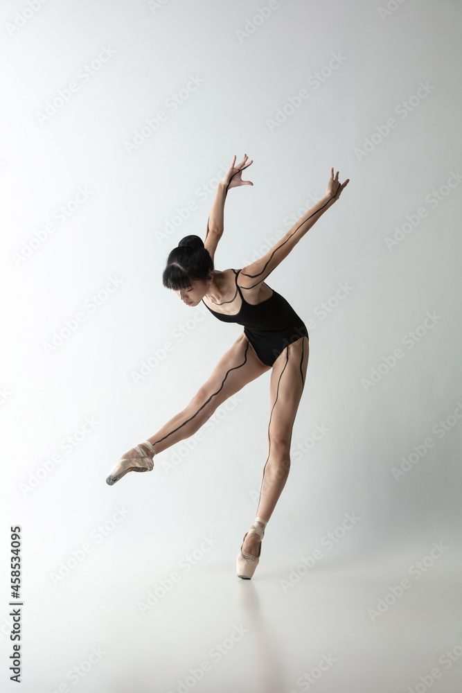 Japanese female ballet dancer, ballerina dancing isolated on light gray studio background. Art, motion, action, flexibility, inspiration concept. Japanese female ballet dancer, ballerina dancing isolated on light gray studio background. Art, motion, action, flexibility, inspiration concept.