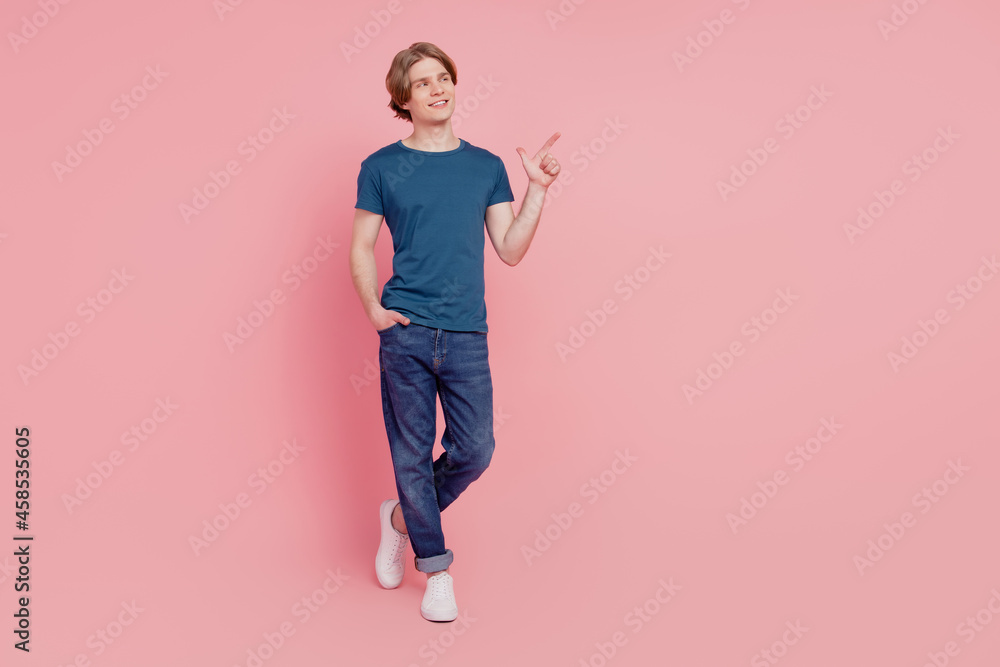 Portrait of curious positive promoter guy indicate finger empty blank space look up on pink background Portrait of curious positive promoter guy indicate finger empty blank space look up on pink background
