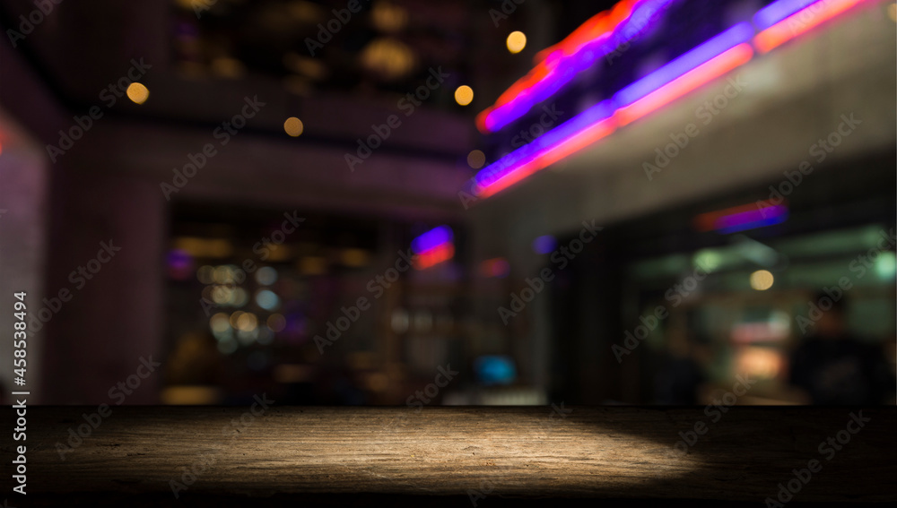 Empty dark wooden table in front of abstract blurred bokeh background of restaurant . can be used for display or montage your products.Mock up for space