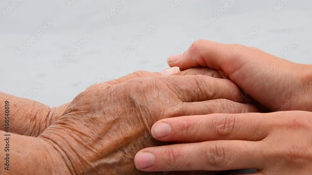 Grandmother's wrinkled hands close up. Old hands of the grandmother. Grandmother holds the hand of an adult granddaughter. Two generations of women are holding hands. Seniors concept. Support