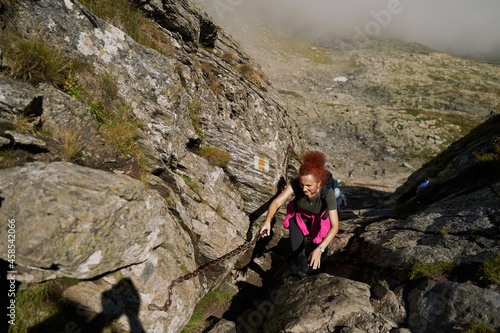 Woman hiker with backpack on a trail in the mountains