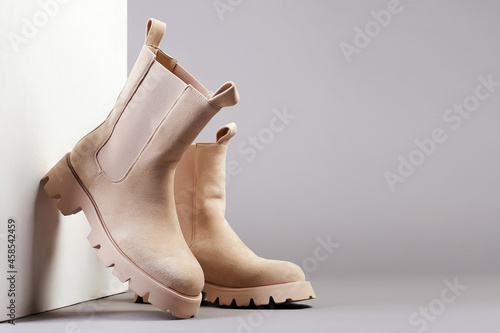 Trendy boots with wooden wall. fashion female shoes still life photo