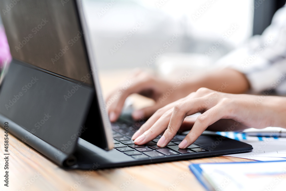 Image of woman hand working using tablet keyboard at office.. Image of woman hand working using tablet keyboard at office..