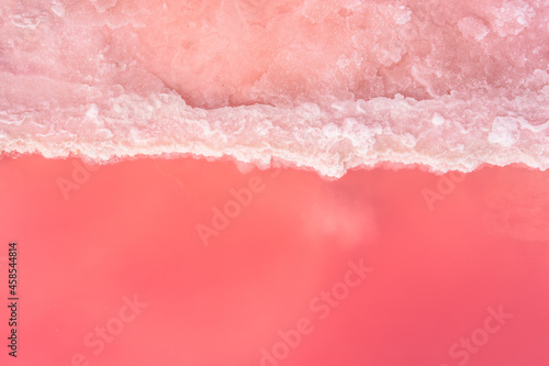 Natural background with pink salt lake. A clear line of pink water and salt. Salt used in medicine, dermatology and spa