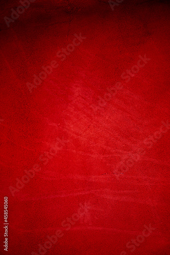 Dark red matte background of suede fabric, closeup. Velvet texture of seamless wine leather.