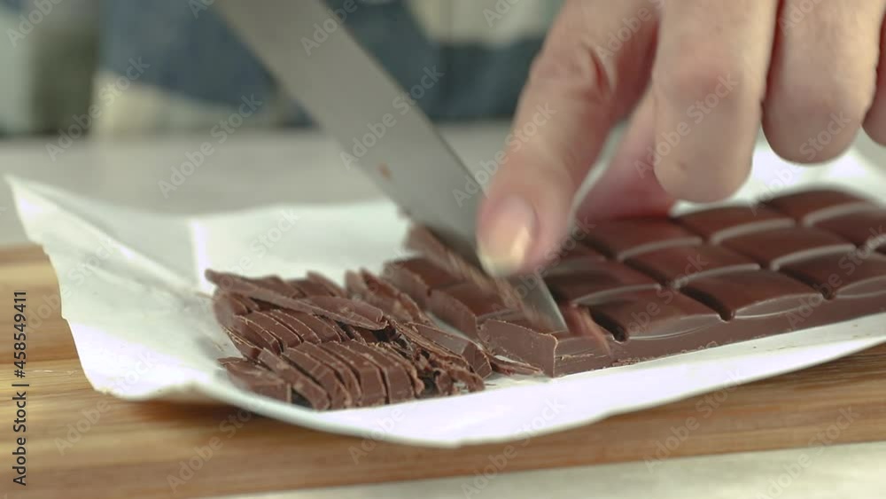 grind with a knife brown chocolate on a white table close-up grind with a knife brown chocolate on a white table close-up