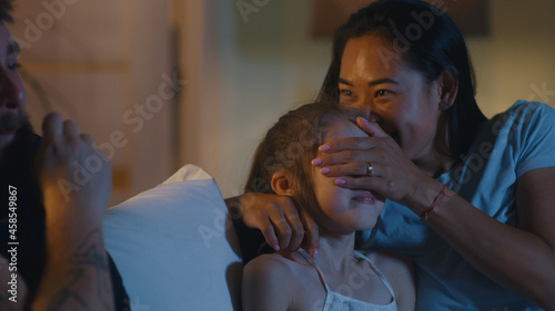 Bilde på lerret Parents watching movie with daughter at night