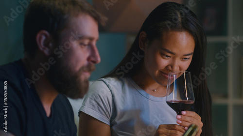Diverse couple drinking wine in living room