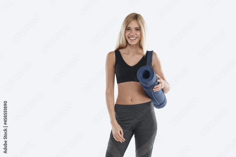 Smiling european sports woman holding fitness mat Smiling european sports woman holding fitness mat