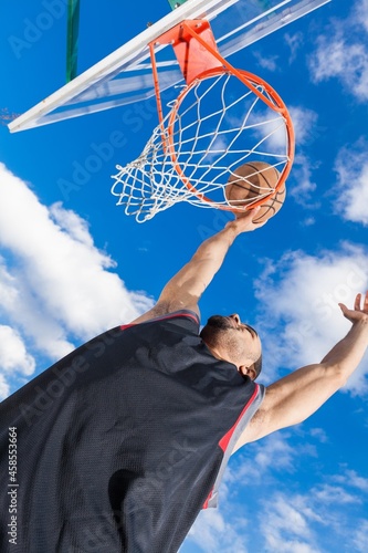 Young sport man playing Basketball with a ball