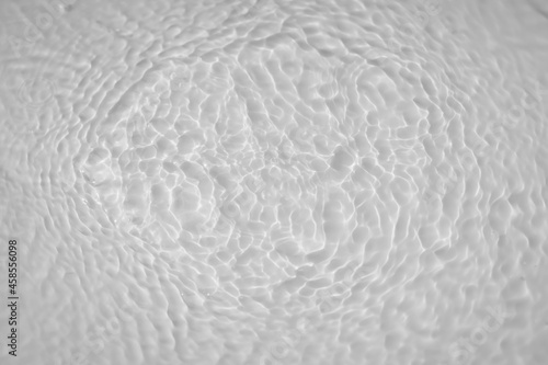 Water tranquil ripple background. Water texture, circles and bubbles on a liquid white surface. Cosmetic products and flat design concept