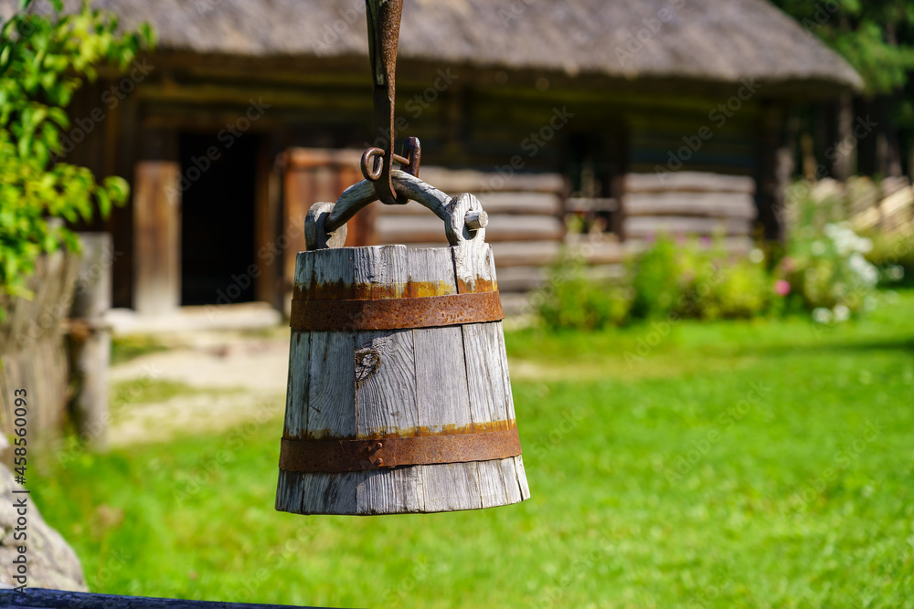 Old wooden bucket to draw water from the well in the field. Old wooden bucket to draw water from the well in the field.
