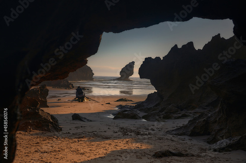Buelna beach, llanes, asturias. Photographer taking pictures at dawn