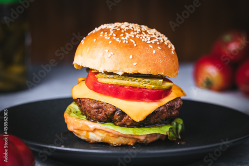 Classic burger with all ingredients on a charcoal grill