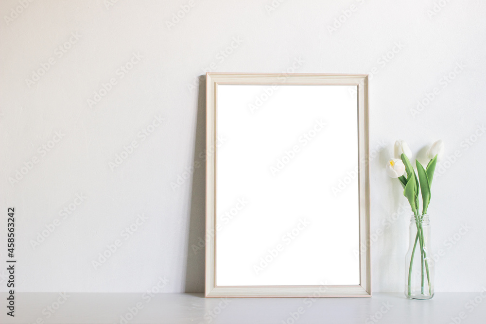 A blank picture frame with flowers on table. A blank picture frame with flowers on table.