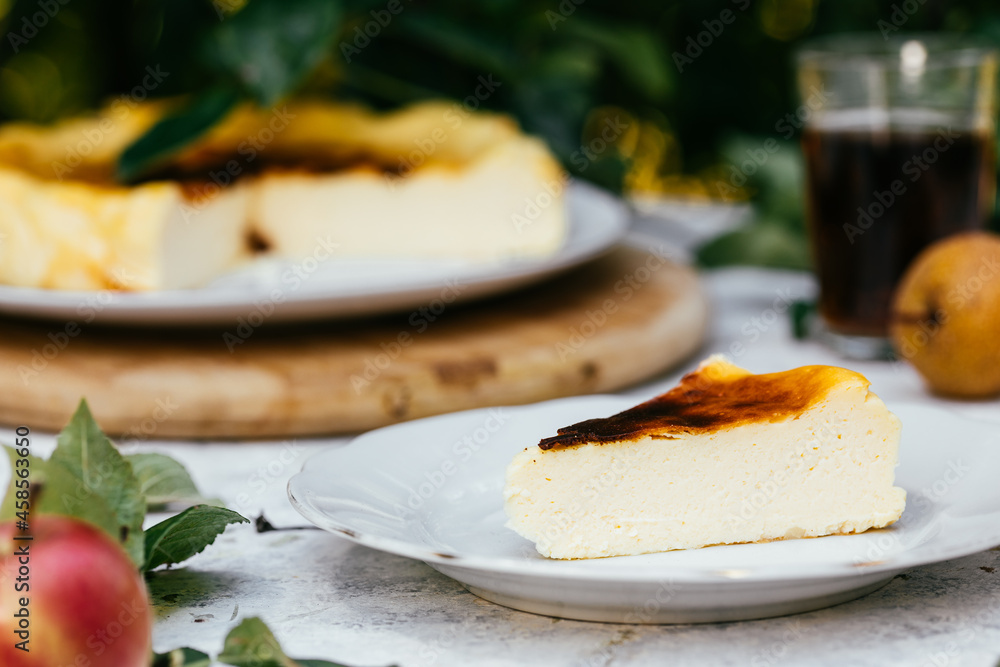 Basque burnt cheesecake served outside on white plate Basque burnt cheesecake served outside on white plate