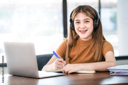 Young Woman College Student Wears Headphone Look at Laptop Study Online at Home