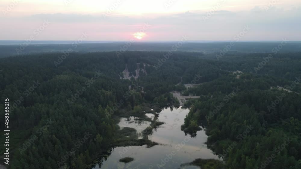 Sunrise over the land of forests and lakes.Flight over ferests small lakes in the early morning at sunrise. Sunrise over the land of forests and lakes.Flight over ferests small lakes in the early morning at sunrise.