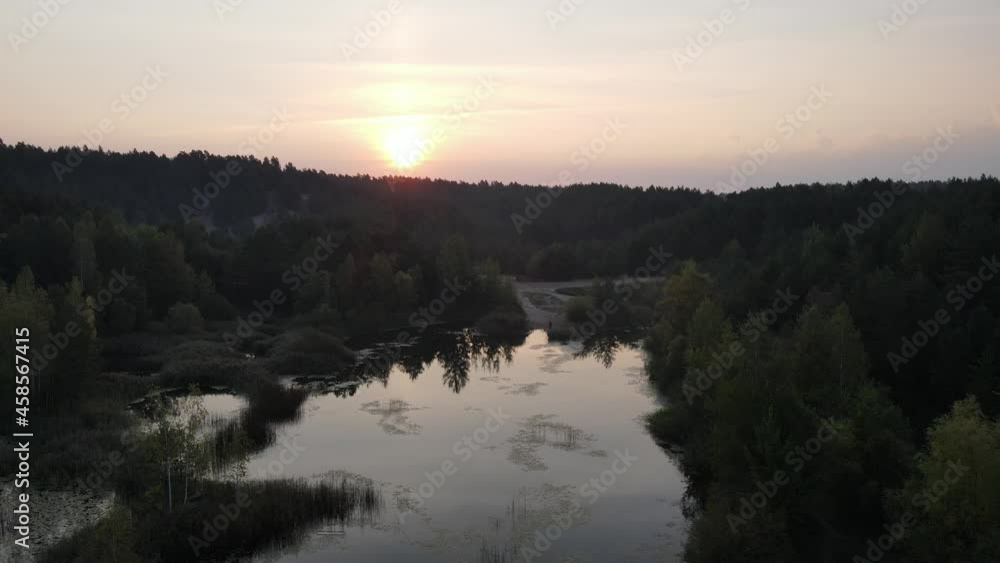 Sunrise over the land of forests and lakes.Flight over ferests small lakes in the early morning at sunrise. Sunrise over the land of forests and lakes.Flight over ferests small lakes in the early morning at sunrise.