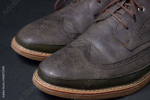 Brown men's shoes on a black background. Leather men's shoes. Men's fashion concept