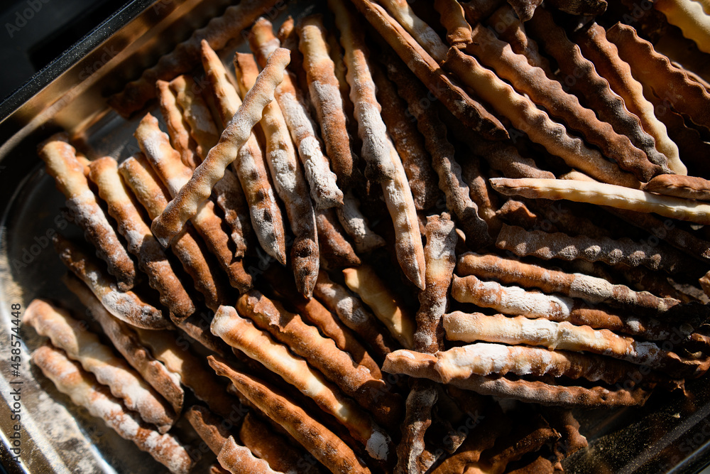 Top view of long crispy breadsticks on silver tray. Top view of long crispy breadsticks on silver tray.