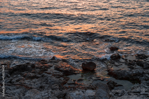 Stones on the seashore. Rocky beach at sunset. Natural background.