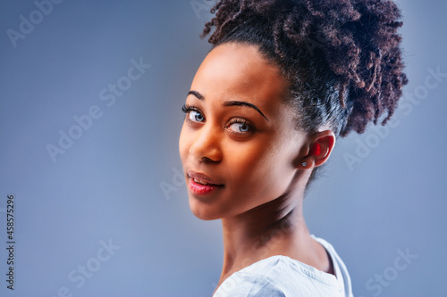 Beautiful young Black woman with blue eyes and curly hair