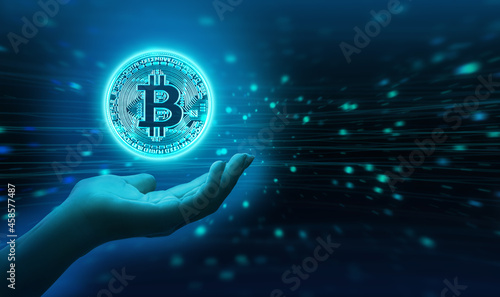Virtual glowing bitcoin with female hand. Futuristic background with copy space. photo